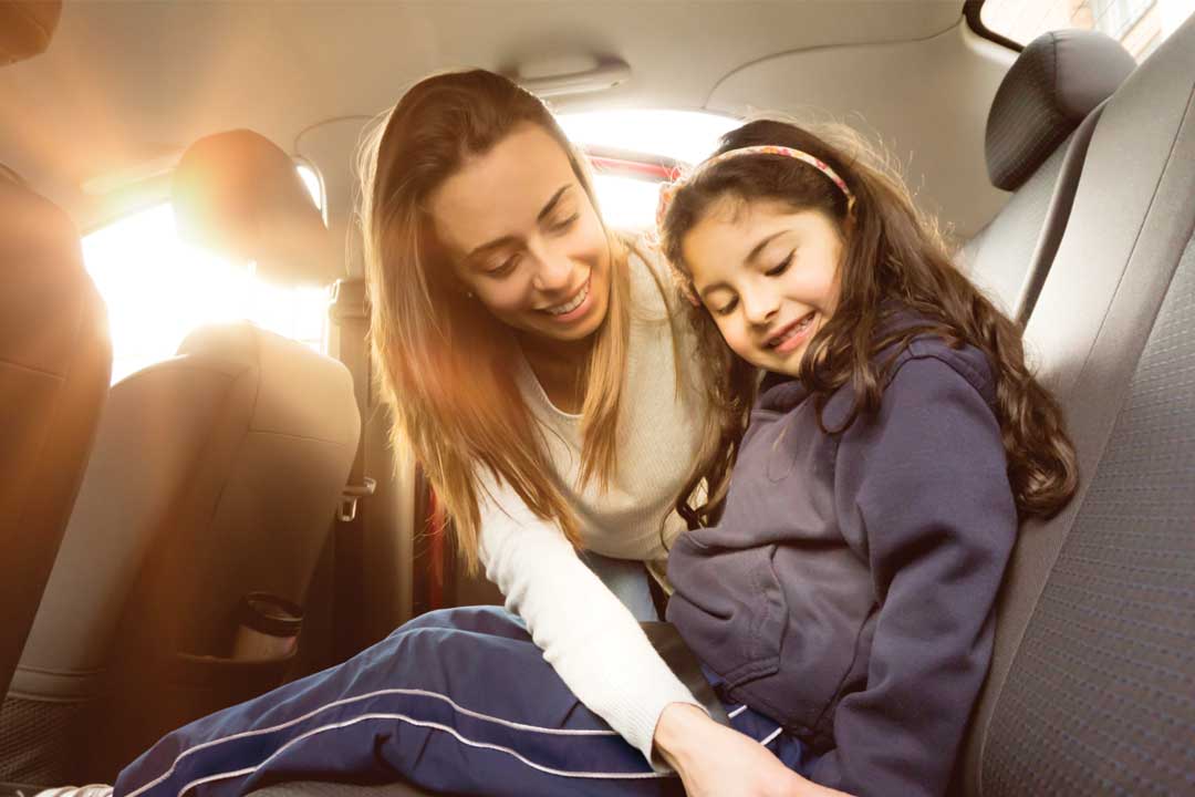 women putting on seatbelt