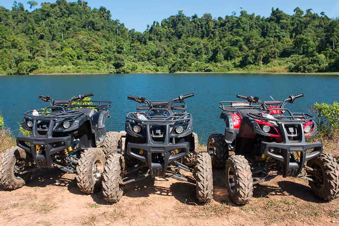 Three ATV's off-roading by the lake