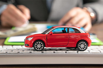 A red toy car on the desk table