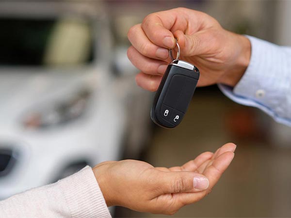 a person handing over keys to someone else