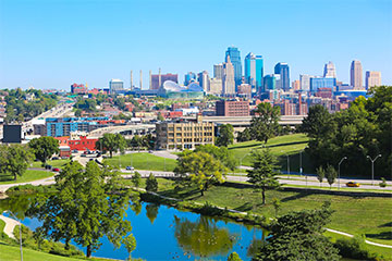 Kansas city skyline in the background with a park and body of water in the forefront