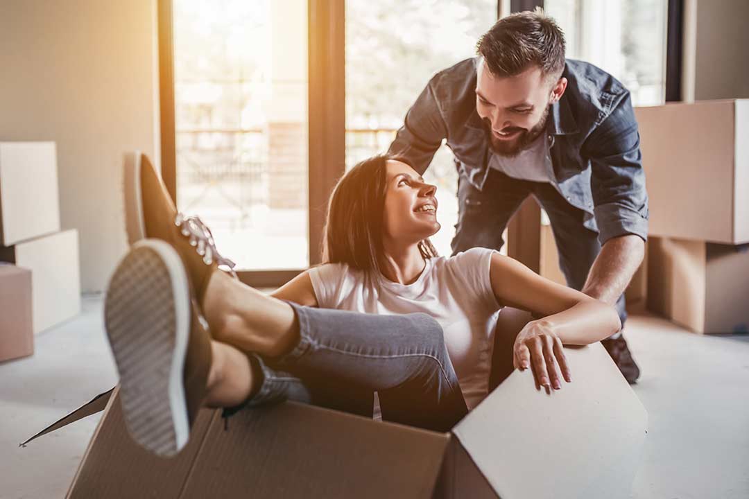 couple moving boxes into apartment