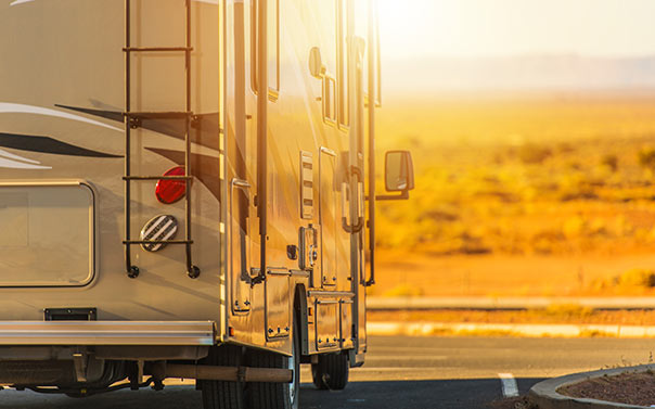 A toy hauler rv on road during sunset